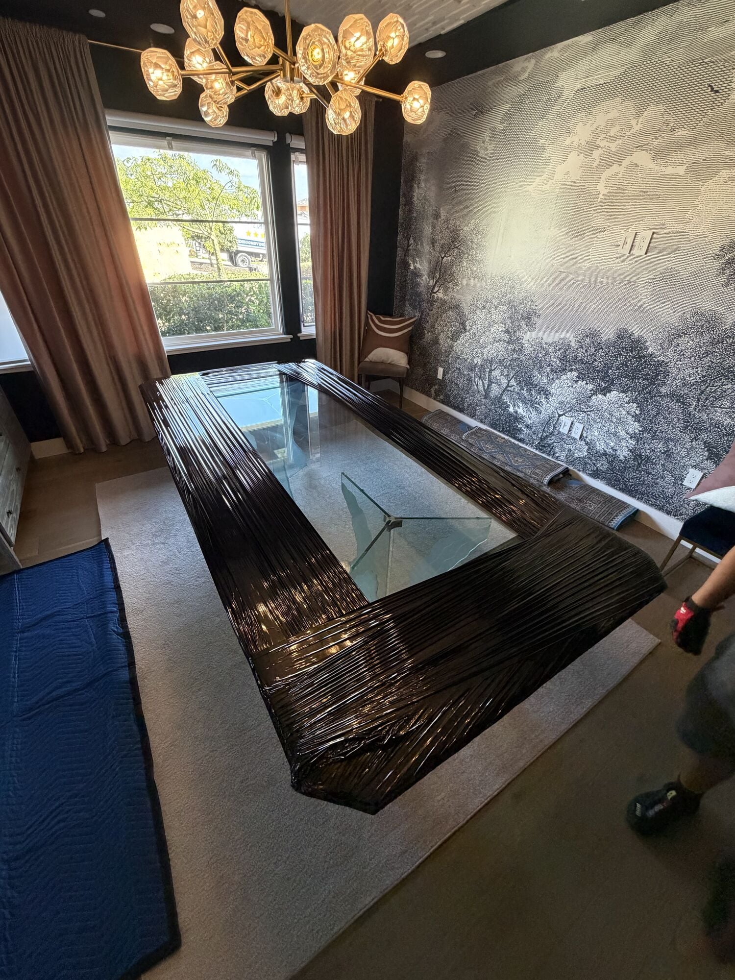 San Diego Moving crew shrink-wrapping a glass dining table in a client's home
